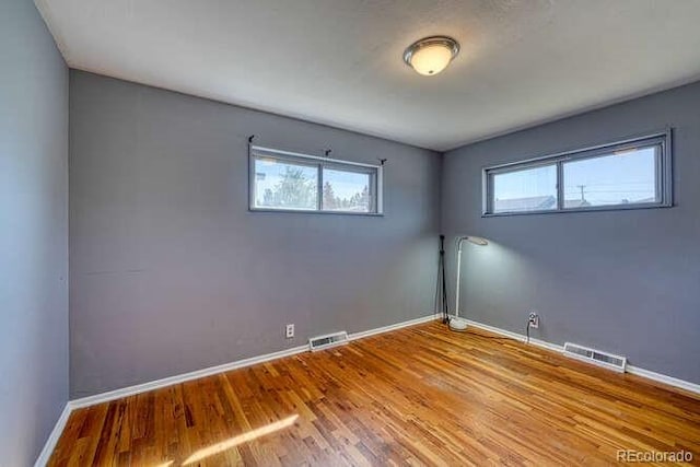 unfurnished room with wood-type flooring