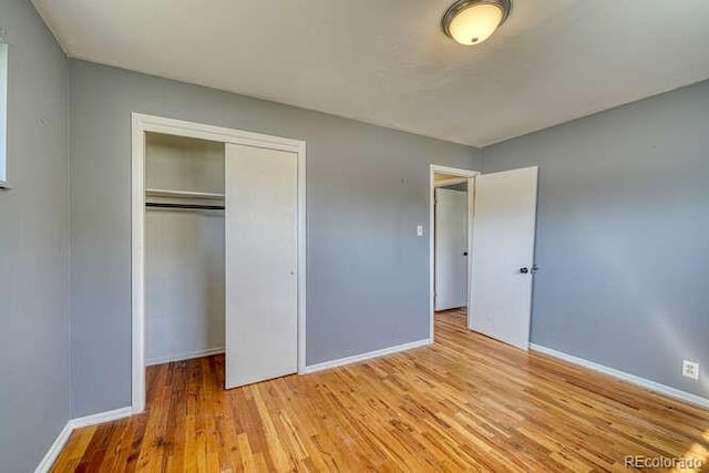 unfurnished bedroom with light wood-type flooring and a closet