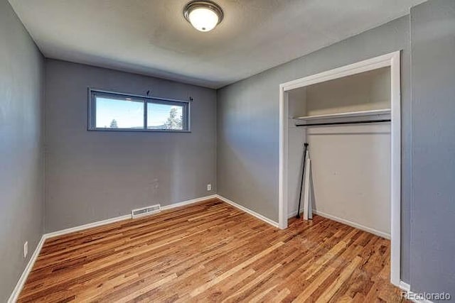 unfurnished bedroom with a closet and light hardwood / wood-style floors