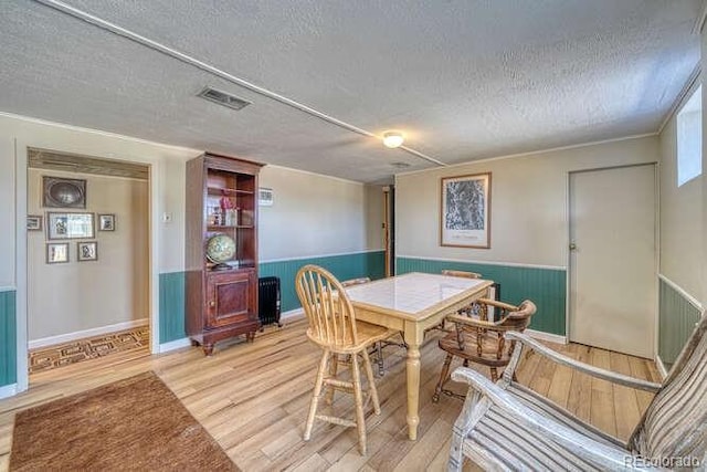 dining space with a textured ceiling and hardwood / wood-style floors