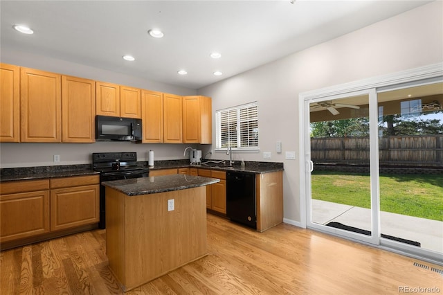 9898 Tourmaline Ct, Parker, CO 80134 - kitchen featuring black appliances, a center island, light wood-style floors, recessed lighting, and dark stone counters