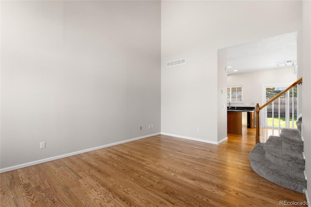 9898 Tourmaline Ct, Parker, CO 80134 - spare room with light wood-type flooring, baseboards, stairs, and a high ceiling