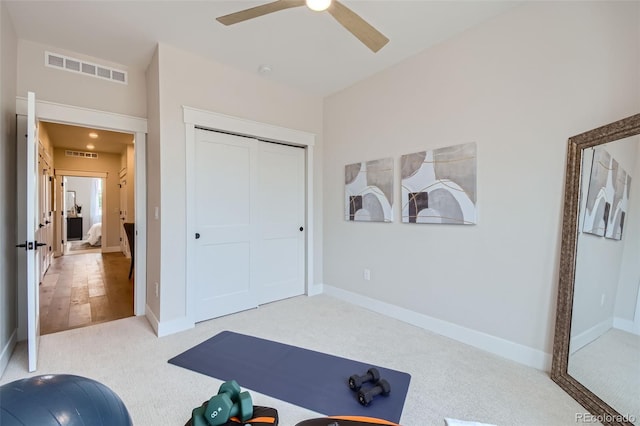 exercise room featuring light carpet and ceiling fan