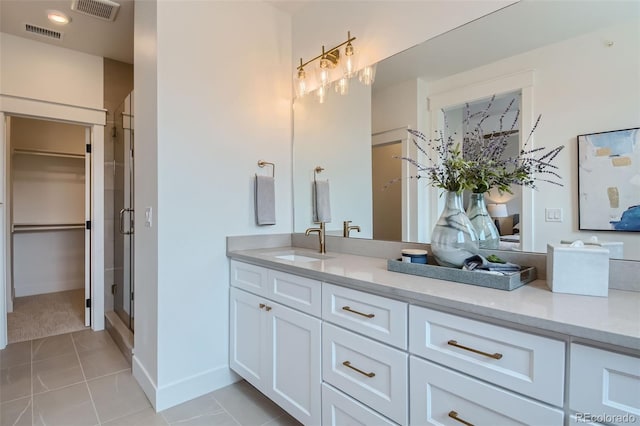 bathroom featuring tile patterned flooring, vanity, and walk in shower