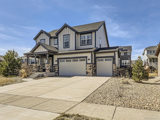 view of front of home featuring driveway, an attached garage, covered porch, stone siding, and board and batten siding