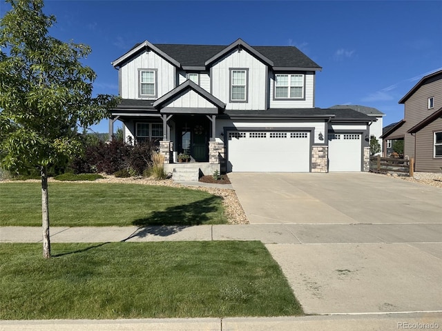 view of front of house with a front lawn, driveway, stone siding, board and batten siding, and a garage