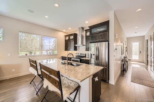 19 S 45th Ave, Brighton, CO 80601 - kitchen featuring a healthy amount of sunlight, appliances with stainless steel finishes, wall chimney exhaust hood, baseboards, and hardwood / wood-style floors