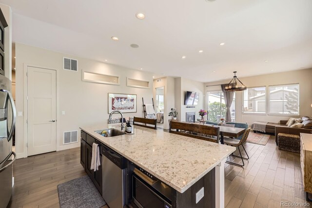 19 S 45th Ave, Brighton, CO 80601 - kitchen with a sink, dishwasher, open floor plan, wood finished floors, and visible vents