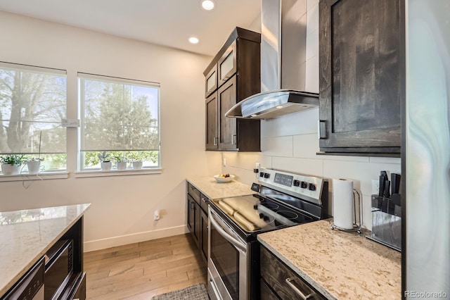 19 S 45th Ave, Brighton, CO 80601 - kitchen featuring wall chimney range hood, dark brown cabinetry, light wood-style flooring, stainless steel appliances, and baseboards