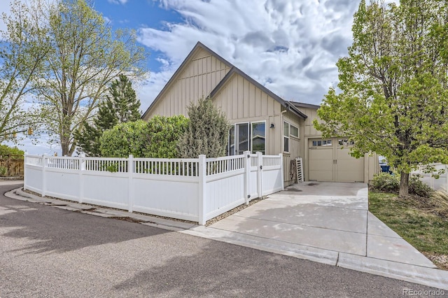 19 S 45th Ave, Brighton, CO 80601 - view of front of home featuring board and batten siding, an attached garage, driveway, and a fenced front yard