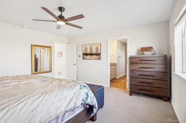 bedroom featuring connected bathroom, light carpet, and ceiling fan