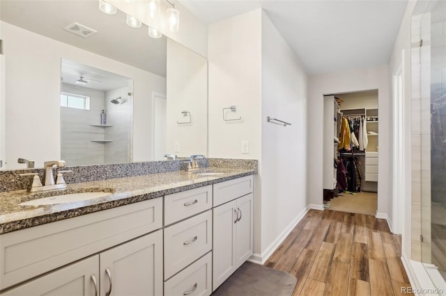 bathroom with vanity, wood-type flooring, and a shower