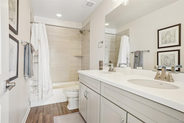 full bathroom with shower / tub combo with curtain, vanity, hardwood / wood-style floors, and toilet