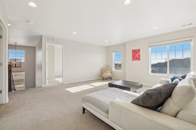 carpeted living room with an inviting chandelier, a healthy amount of sunlight, and a mountain view