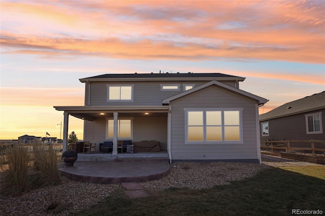 back house at dusk featuring a patio area