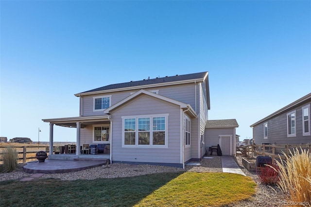 back of house with a patio and a lawn