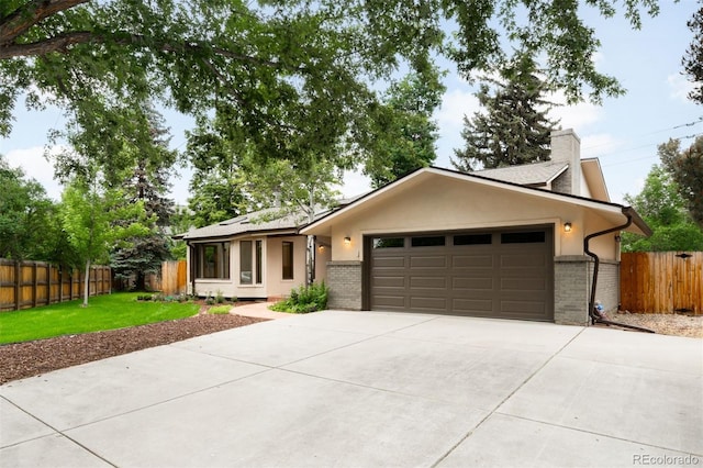 655 Cree Cir, Boulder, CO 80303 - ranch-style home with brick siding, concrete driveway, an attached garage, a chimney, and stucco siding