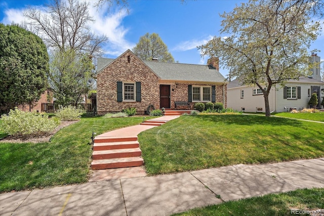 1572 Leyden St, Denver, CO 80220 - view of front of house with roof with shingles, a chimney, a front yard, and brick siding