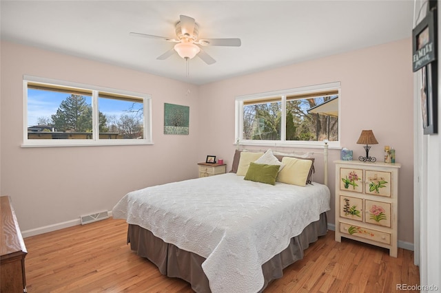 bedroom with multiple windows, ceiling fan, and light hardwood / wood-style flooring