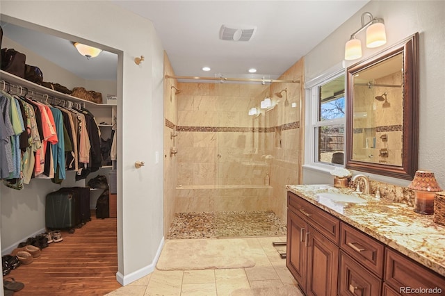 bathroom featuring vanity and tiled shower