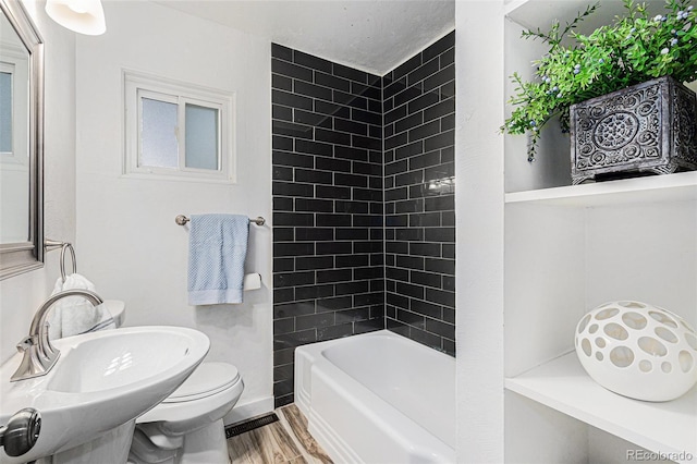 3715 Manchester St, Colorado Springs, CO 80907 - bathroom featuring wood finished floors, toilet, baseboards,  shower combination, and a sink
