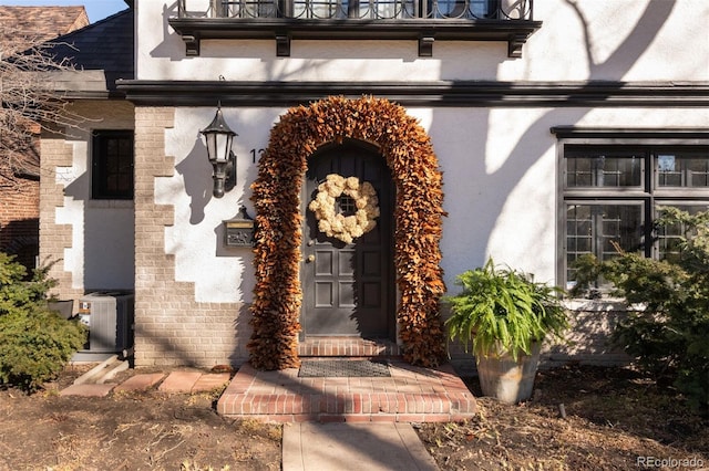 property entrance with brick siding and central air condition unit