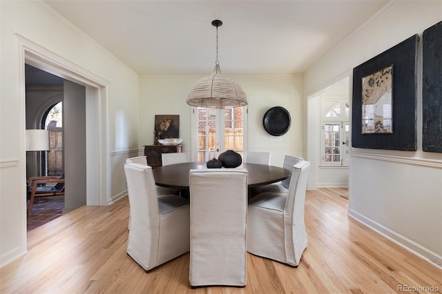 dining room featuring crown molding, plenty of natural light, and light wood finished floors