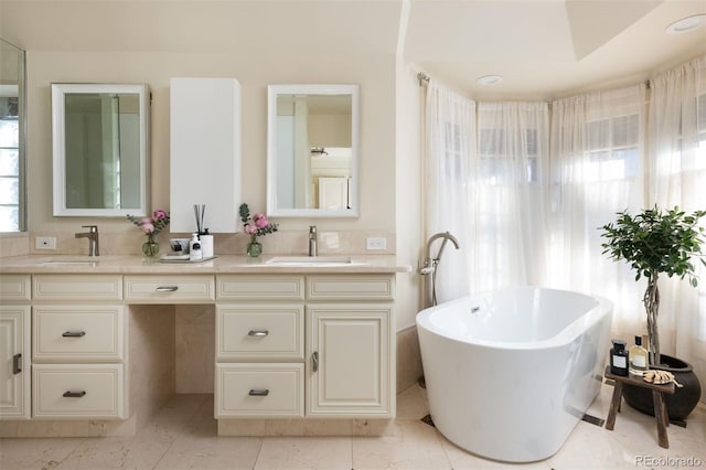 full bath with a sink, a freestanding bath, and double vanity