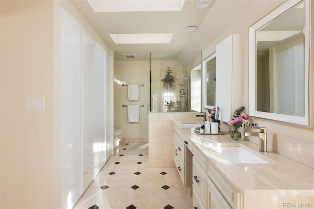 full bath with visible vents, a skylight, a sink, and toilet