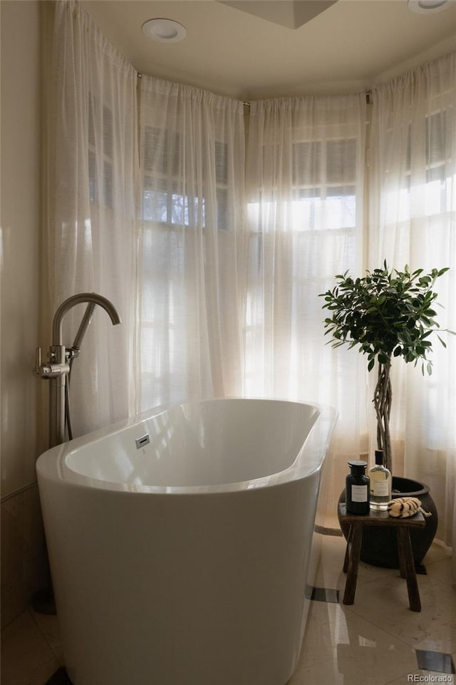 bathroom featuring a freestanding tub and tile patterned floors