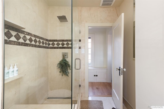 full bath with a shower stall and visible vents