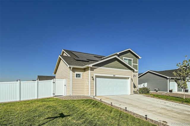 view of front facade with a garage, solar panels, and a front yard