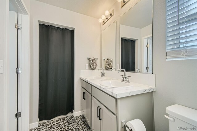 bathroom featuring tile patterned floors, walk in shower, vanity, and toilet