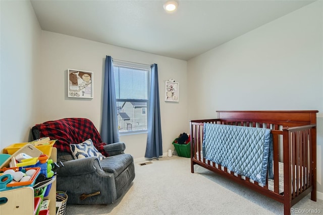 bedroom featuring a crib and carpet floors