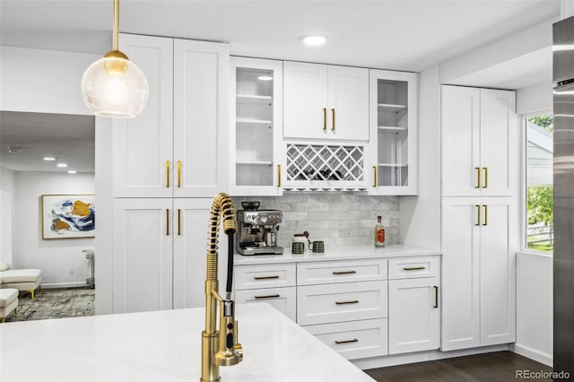 bar featuring backsplash, decorative light fixtures, dark hardwood / wood-style floors, and white cabinets