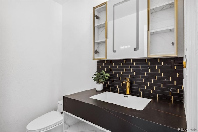 bathroom featuring toilet, decorative backsplash, and vanity