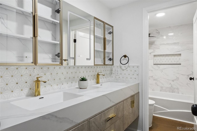 full bathroom with vanity, toilet, hardwood / wood-style floors, and tiled shower / bath