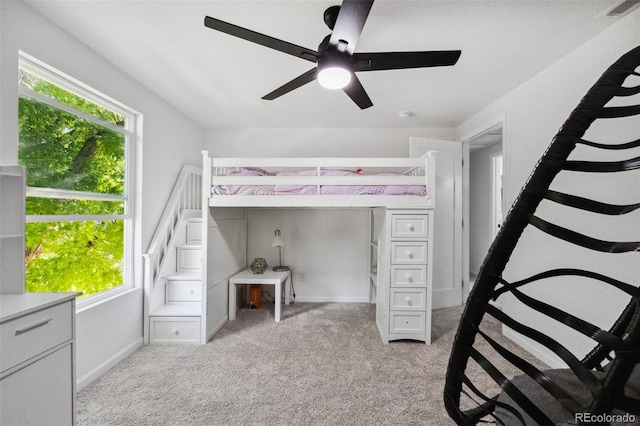 unfurnished bedroom with light carpet, multiple windows, and ceiling fan