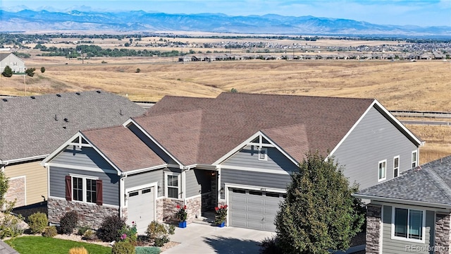 view of front of property with a mountain view, a garage, and a rural view