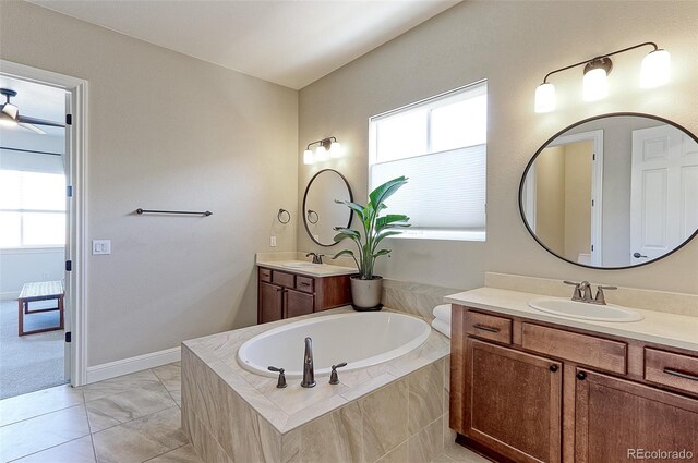 bathroom featuring tiled bath and vanity