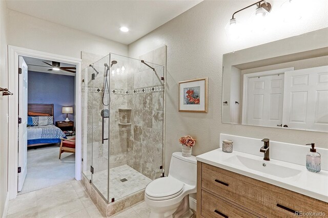 bathroom with vanity, walk in shower, tile patterned flooring, toilet, and ceiling fan