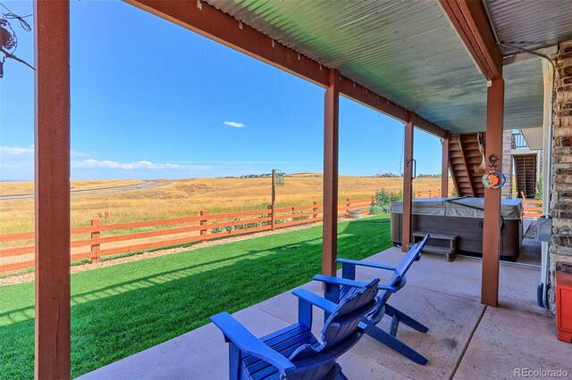 view of patio featuring a hot tub and a rural view