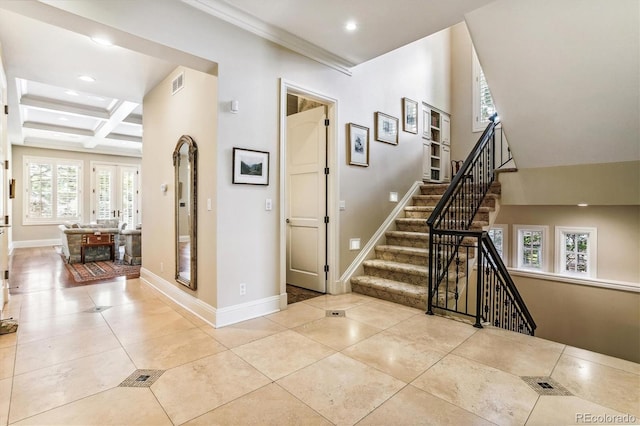 tiled foyer entrance with beamed ceiling, ornamental molding, and coffered ceiling