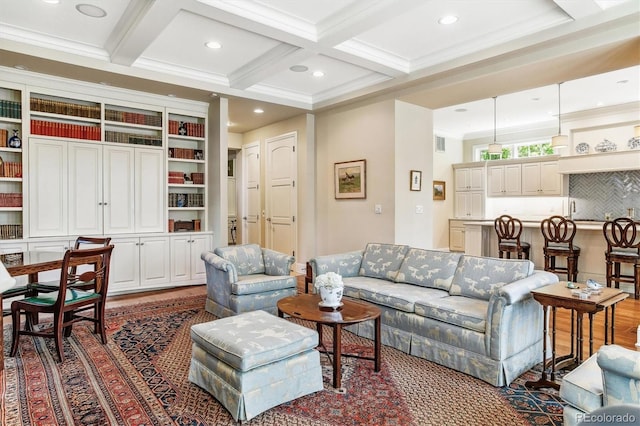 living room with coffered ceiling, crown molding, and beamed ceiling