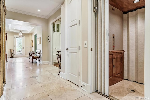 corridor with light tile patterned floors, crown molding, a raised ceiling, and elevator