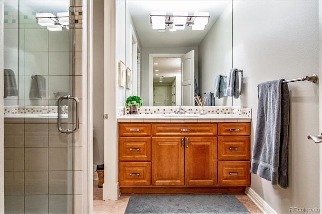 bathroom with tile patterned flooring, vanity, and a shower with door