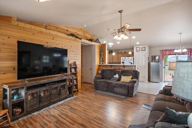 1176 E Purcell Ln, Pueblo, CO 81007 - living area featuring vaulted ceiling, ceiling fan, light wood-style floors, wooden walls, and a chandelier