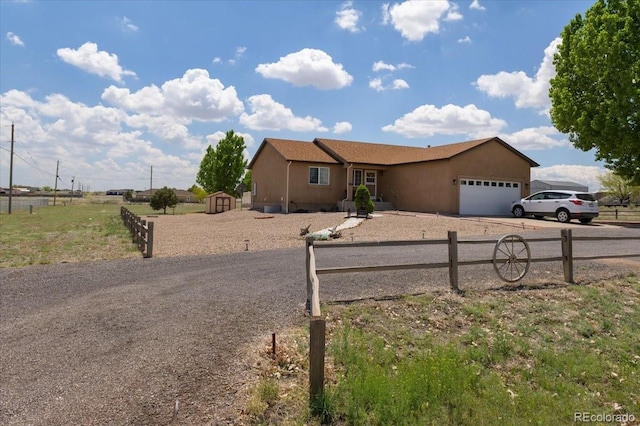 1176 E Purcell Ln, Pueblo, CO 81007 - ranch-style home with driveway, a garage, and a storage shed