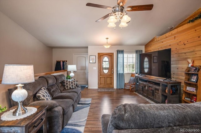 1176 E Purcell Ln, Pueblo, CO 81007 - living room featuring vaulted ceiling, ceiling fan, wood finished floors, and wood walls