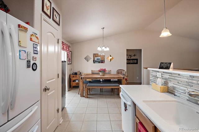 1176 E Purcell Ln, Pueblo, CO 81007 - kitchen featuring white appliances, a sink, vaulted ceiling, light tile patterned flooring, and light countertops